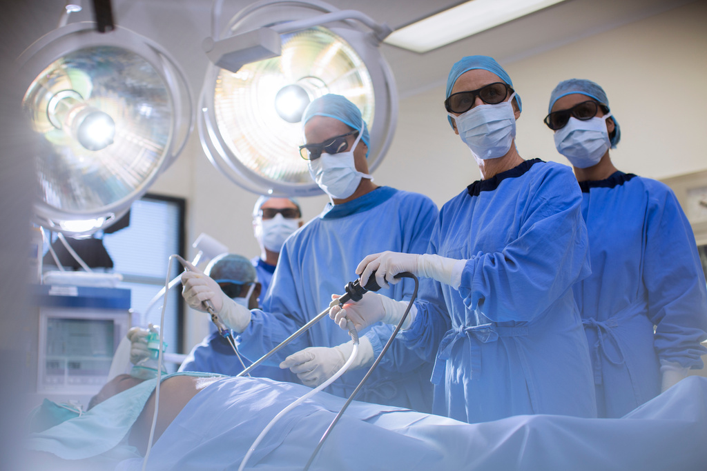 Team of doctors performing laparoscopic surgery in operating theater